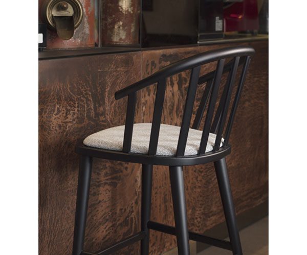 A black bar stool with a white cushion