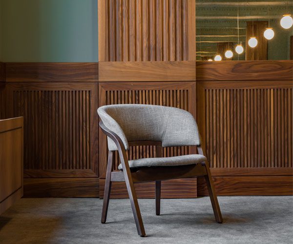 A chair sitting in front of a wooden wall